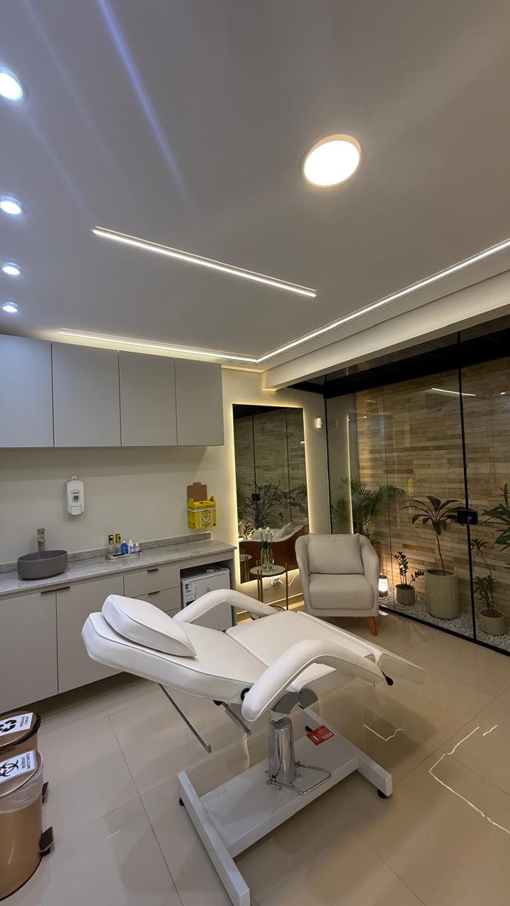 Sala de atendimento com maca estética e iluminação linear